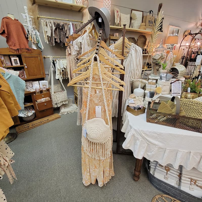 Floor-to-ceiling displays inside Old Soul — hand-selected apparel on a rail, woven baskets, a galvanized tub, and warm wood dressers under chandelier light